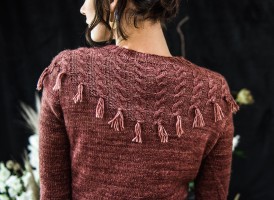 Узор с косами, украшающий кокетку пуловера, связанного спицами