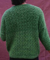 Женский пуловер связан ненавязчивым узором с ажурными элементами